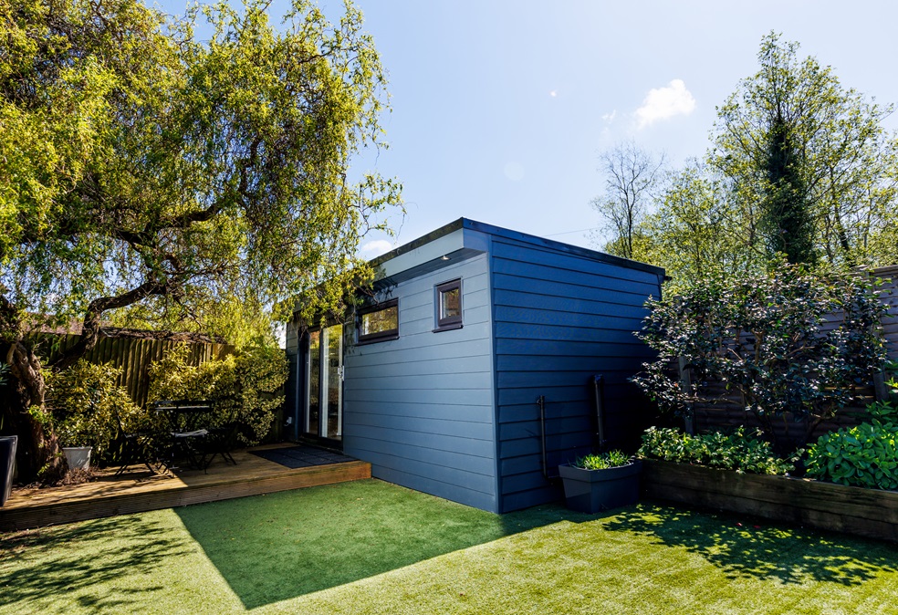Bespoke angled garden annexe in Gomshall, Surrey, with anthracite Hardie weatherboard cladding