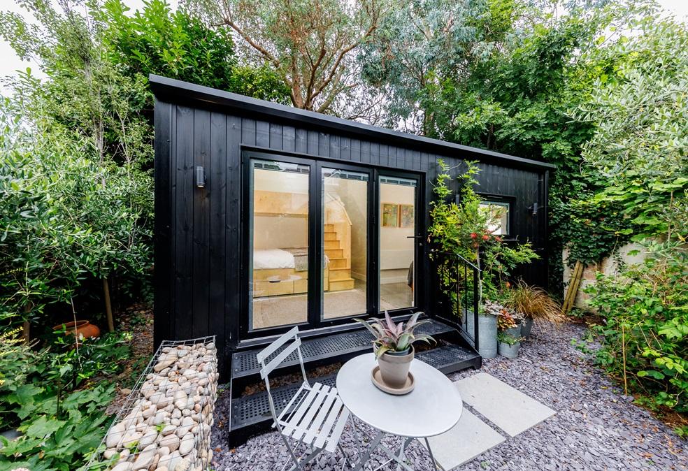 Custom-built garden annexe in Worthing with black corrugated metal cladding and angled roof